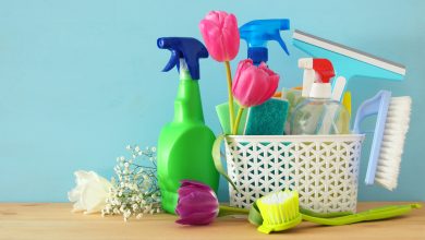 Spring cleaning concept with supplies on wooden table.