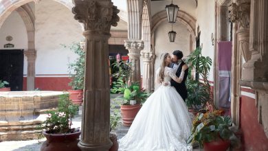 the bride and groom kiss among the columns and flowers