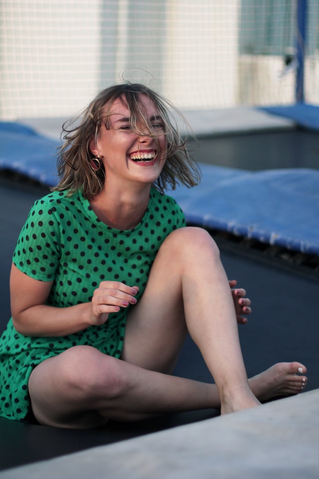 person sitting on trampoline and smiling