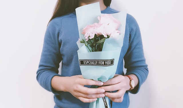 woman holding pink flower bouquet