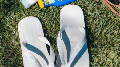 Sunscreens - Flip-flops, sunblock, and sunglasses on grass evoke summertime leisure in Brazil.