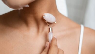 Skincare Tools - Close-up of a woman using a facial roller during her skincare routine, enhancing beauty and relaxation.