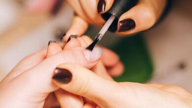 Nail Care Kits - Close-up of a manicurist applying nail polish during a professional manicure session.