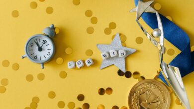 Best Time To Buy - Conceptual flat lay of a trophy, medal, and clock with 'FOR WIN' letters, symbolizing victory and achievement.