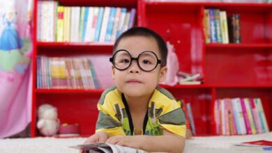 Kids’ Books - Boy Standing Near Bookshelf