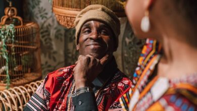 Birdcages - A joyful moment of African American adults in traditional clothes, sharing smiles and happiness.