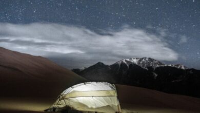 Sleeping Bag - A glowing tent under a starry night sky in a serene desert landscape.