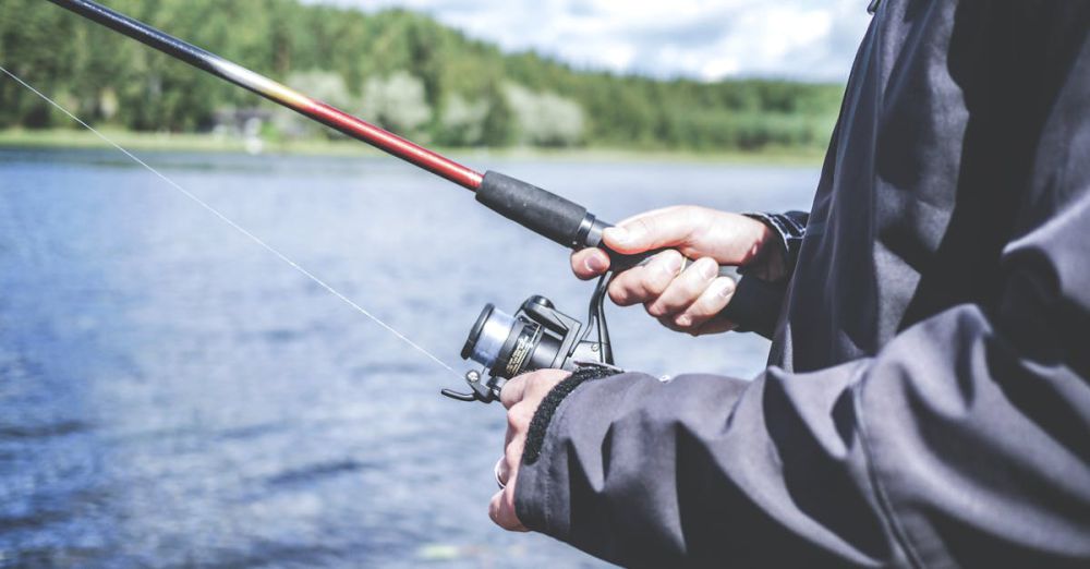 Fishing Rod - A man enjoys fishing at a lake, showcasing a relaxed outdoor hobby in nature.