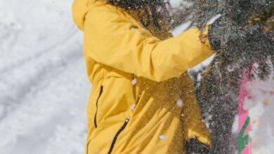 Snowboarding Gear - Female snowboarder in yellow jacket enjoying winter snow on a mountain slope.