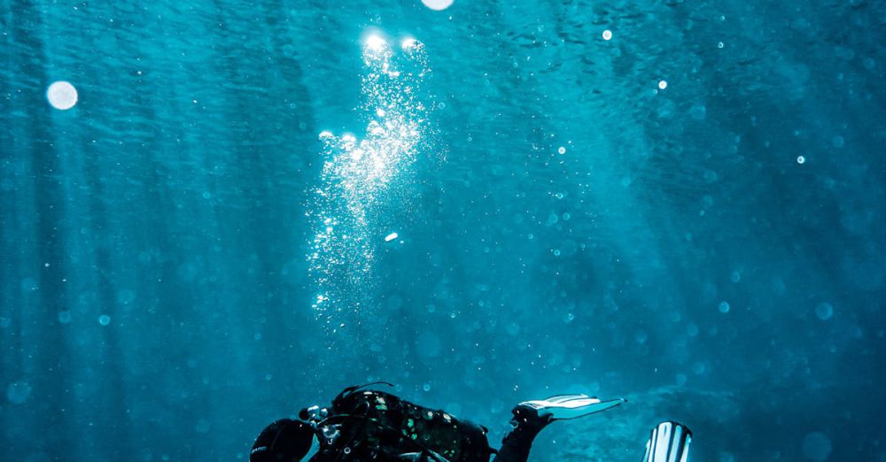 Diving Equipment - Scuba diver exploring underwater reef in vibrant turquoise waters, capturing marine life beauty.