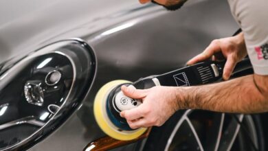 Car Wax - A man meticulously polishing a luxury sports car in a garage, focusing on the front section.