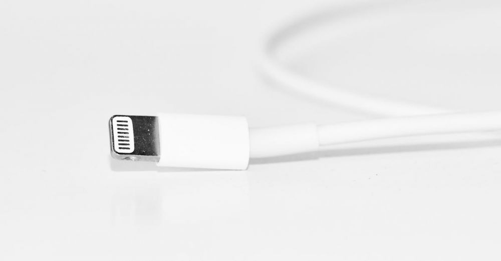 Charger - Minimalist close-up of a white charging cable, useful for tech themes.