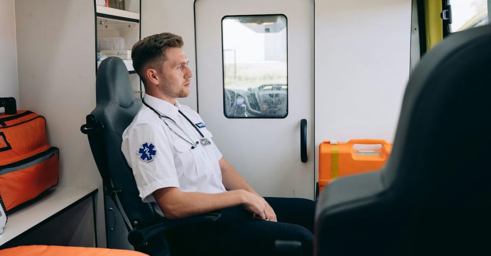 Zero-Waste Kits - A paramedic in uniform sits inside an ambulance, reflecting on a dispatch.