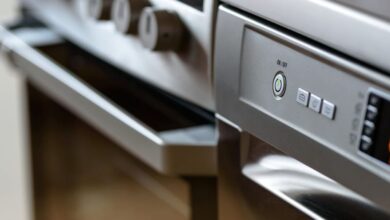 Kitchen Appliances - Close-up view of modern stainless steel kitchen appliances with focus on dishwasher and oven.