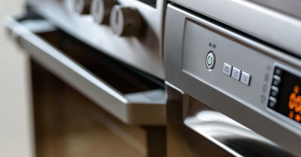 Kitchen Appliances - Close-up view of modern stainless steel kitchen appliances with focus on dishwasher and oven.