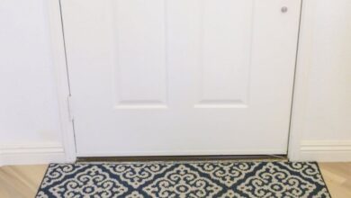 Robot Vacuum Cleaner - A modern robotic vacuum cleaner operating on a patterned rug near a white door.