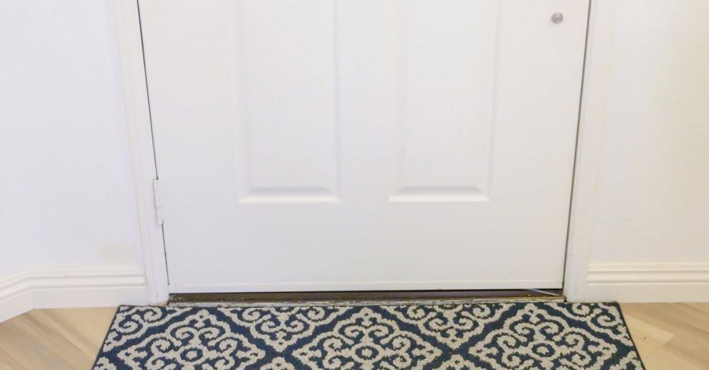 Robot Vacuum Cleaner - A modern robotic vacuum cleaner operating on a patterned rug near a white door.