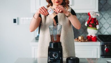 Blender - A woman pours a sachet into a blender in a festive kitchen setting.