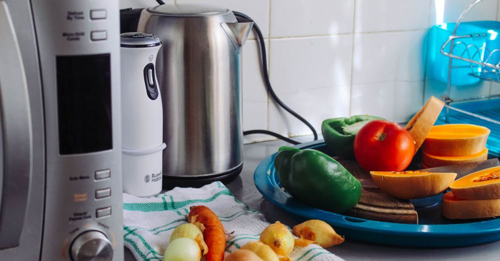 Home Appliances - A modern home kitchen counter displaying fresh vegetables and appliances, ideal for healthy cooking.