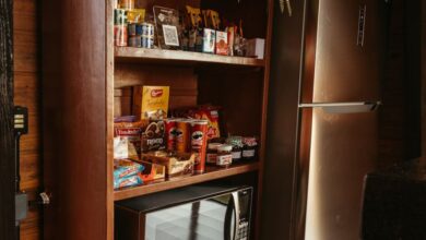 Smart Refrigerator - Wooden shelf with snacks and wine, next to modern fridge, in a rustic kitchen setting.