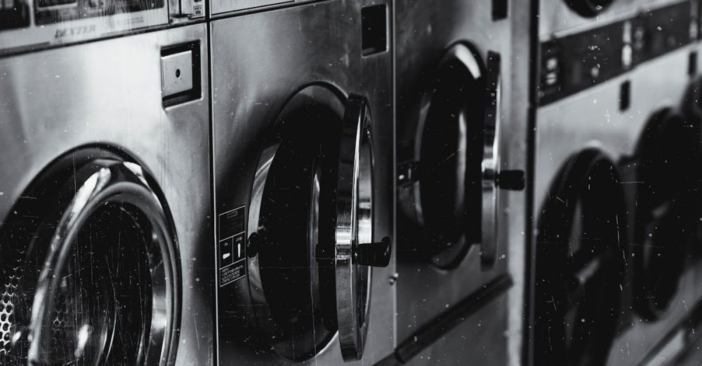 Washing Machine - Black and white image of industrial washing machines in a retro style laundry facility.