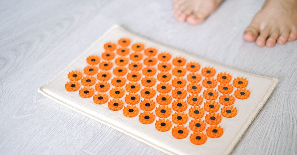 Acupressure Mat - Close-up of a foot acupressure mat on a wooden floor, ideal for relaxation therapies.