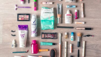 Beauty Products - A diverse collection of beauty and grooming products neatly arranged on a wooden surface in a flatlay style.