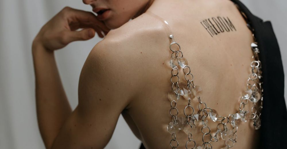 Crystal Jewelry - A conceptual studio portrait showcasing a person with a 'freedom' tattoo and crystal chains on their back.