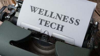 Fitness Trackers - Close-up of a typewriter with paper displaying 'WELLNESS TECH'.