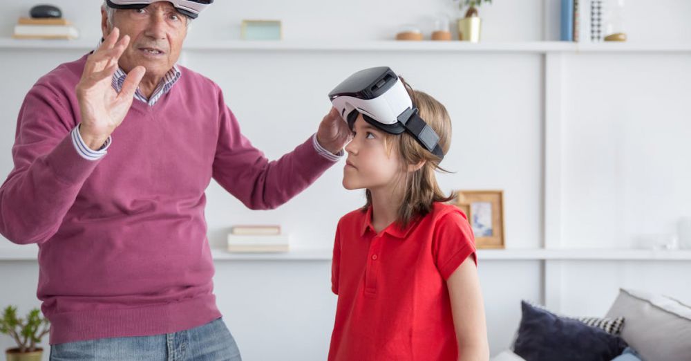 VR Headsets - A senior man and young girl explore virtual reality together indoors.