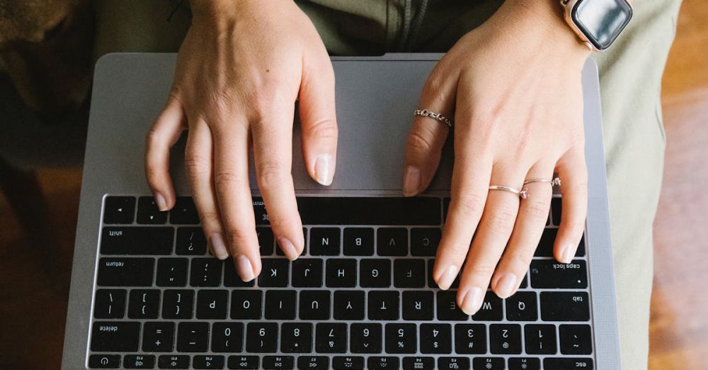 Smart Rings - Top view crop anonymous female browsing modern netbook and typing on keyboard in light room