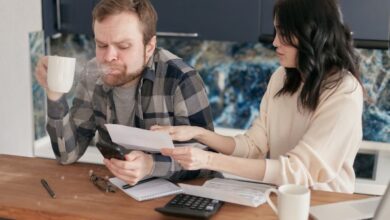 Stress Gadgets - Couple discussing financial documents and budgeting at a kitchen table.