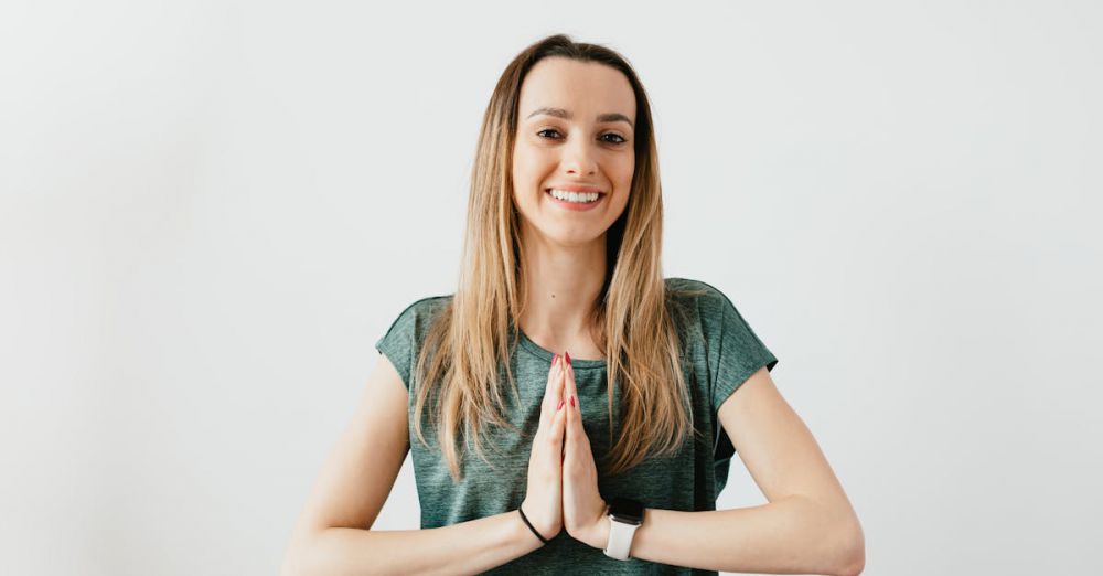 Wearable Cameras - Cheerful woman in green shirt practicing yoga indoors, embracing peace and wellness.