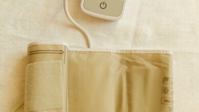 Blood Pressure Monitors - Top view of a digital blood pressure monitor and cuff on white fabric background.