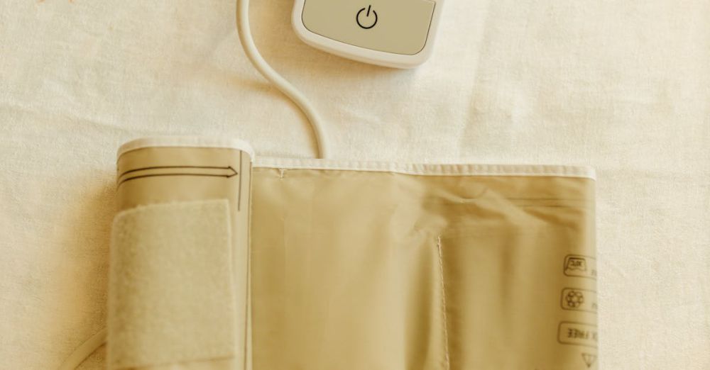 Blood Pressure Monitors - Top view of a digital blood pressure monitor and cuff on white fabric background.