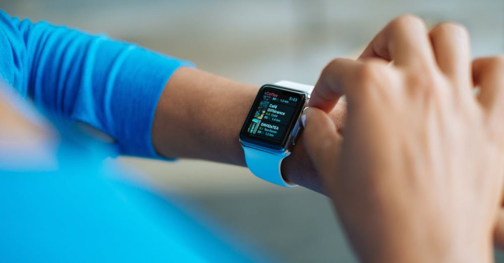 Fitness Gadgets - Person interacting with a smartwatch, showing a fitness application on the screen.