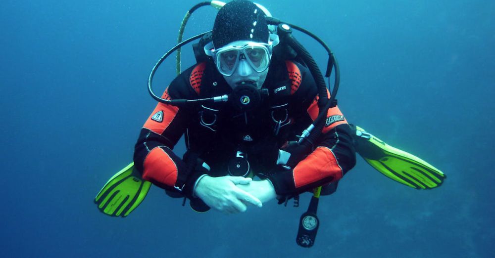 Swimming Devices - A diver in a drysuit exploring the ocean depths with full scuba gear.