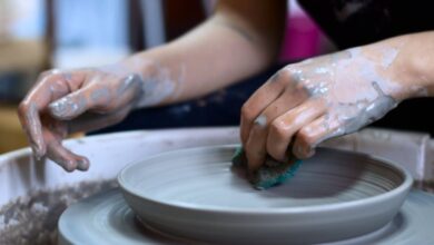 Pottery - Close-up of hands shaping pottery clay on a spinning wheel in a creative studio.