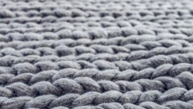 Rugs - Macro photograph showing the intricate details of grey knitted wool fibers.