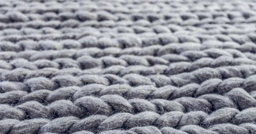 Rugs - Macro photograph showing the intricate details of grey knitted wool fibers.