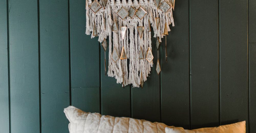 Quilts - Cozy bedroom featuring a stylish macramé wall hanging and a pillow with 'Good Vibes' text.