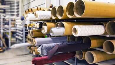 Fabrics - Rows of textile rolls stored in a factory for industrial manufacturing.