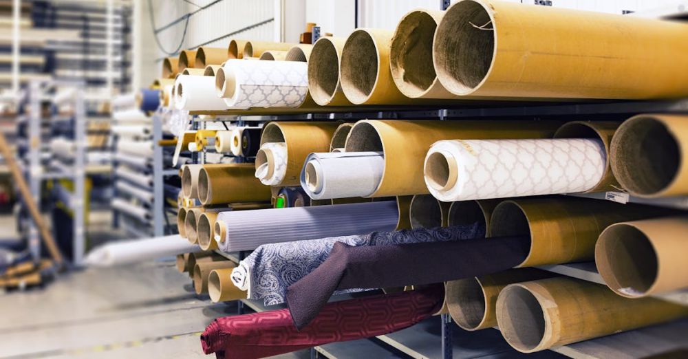 Fabrics - Rows of textile rolls stored in a factory for industrial manufacturing.