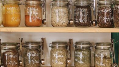 Food Storage - Glass jars filled with various spices and ingredients on wooden shelves promoting zero waste lifestyle.