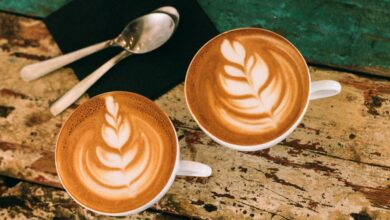 Coffee Cups - Café latte art on rustic table in Paris, capturing warm coffee moments.