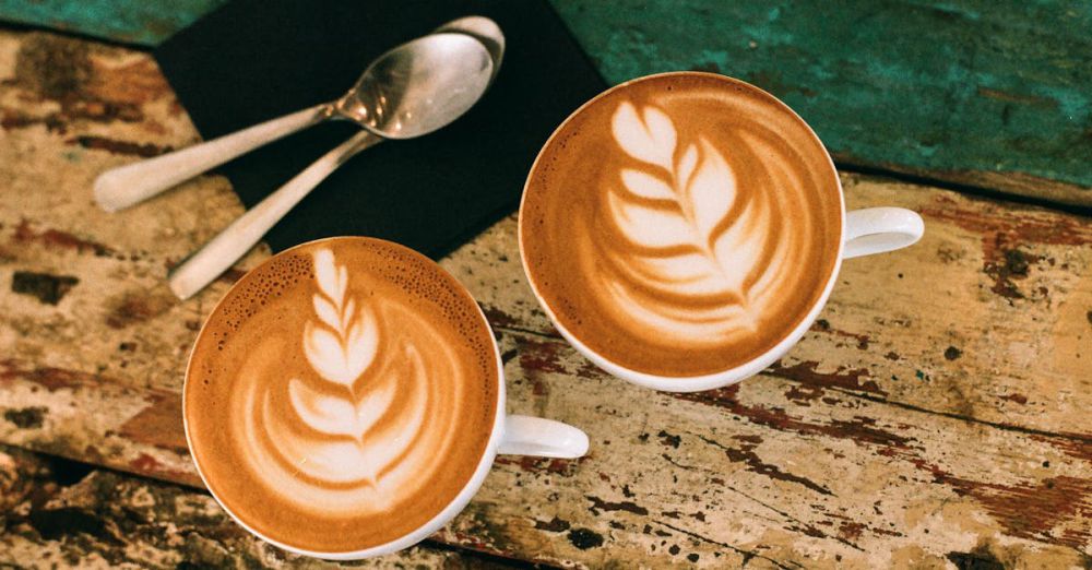 Coffee Cups - Café latte art on rustic table in Paris, capturing warm coffee moments.