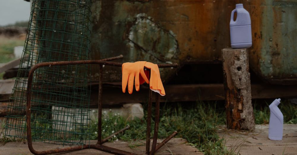 Cleaning Bottles - An outdoor scene featuring a rusted chair, orange latex gloves, and cleaning bottles on a wooden floor.