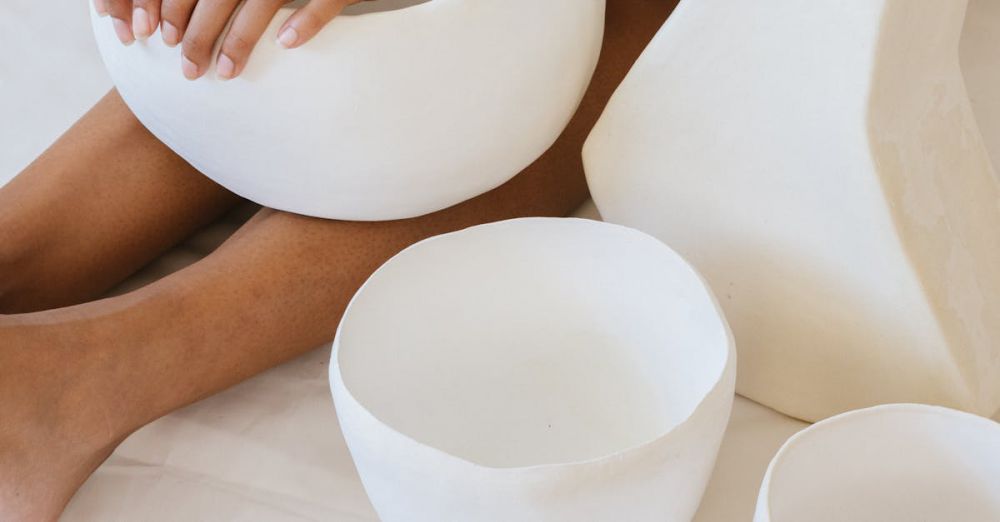 Bowl Covers - Top view of a woman crafting white ceramic pottery pieces, showcasing artisan skills and minimalist design.