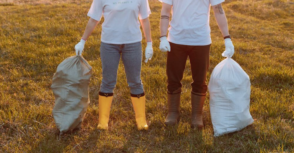 Trash Bags - Two volunteers holding trash bags in a field during sunset, promoting environmental cleanliness.