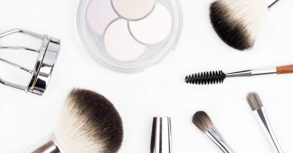 Beauty Products - Flat lay of various makeup brushes and tools on a white background.